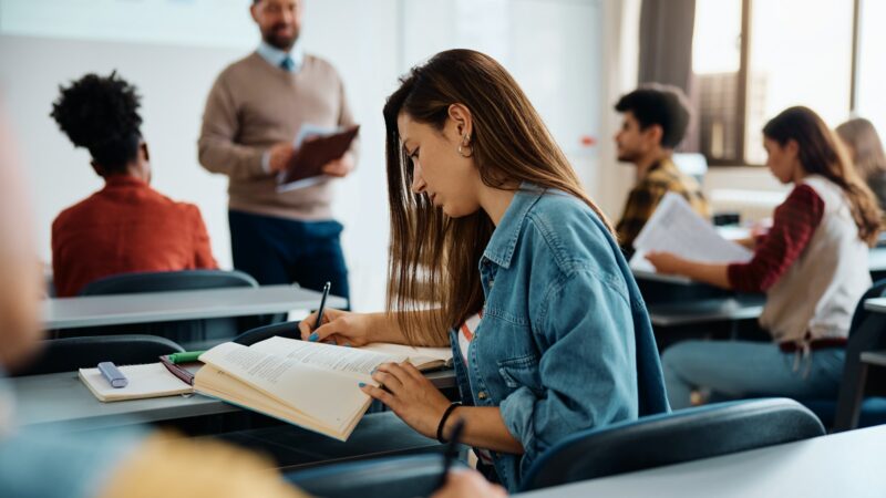 Female student taking notes during a class at the university.