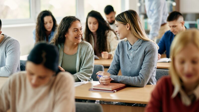 Happy female students talking during a class at the university.